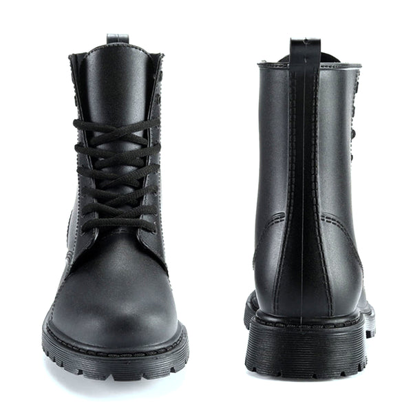 AllSlides Nomad Black waterproof boots displayed outdoors in rain, showcasing durable footwear for wet weather.