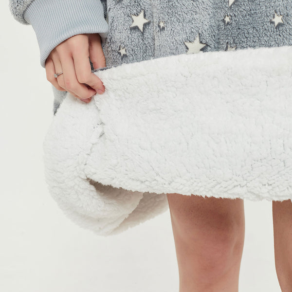Snuggyz glow in the dark stars hoodie blanket showing a soft, cozy hoodie with star patterns in a dark, glowing design.