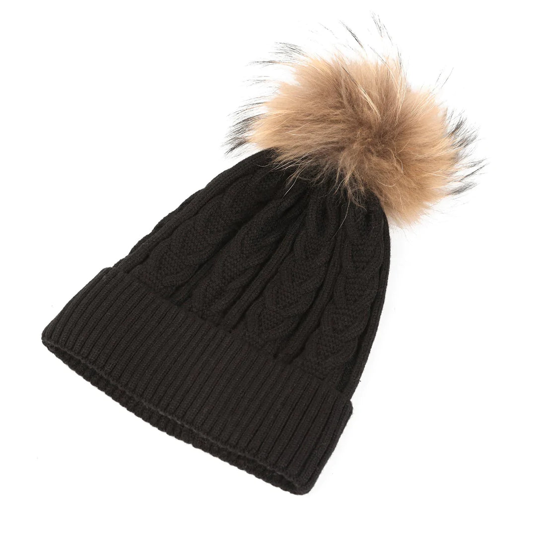 Black and natural cable-knit Pom Pom Beanie by Snuggyz featuring a fluffy pom pom on top, perfect for cold weather.