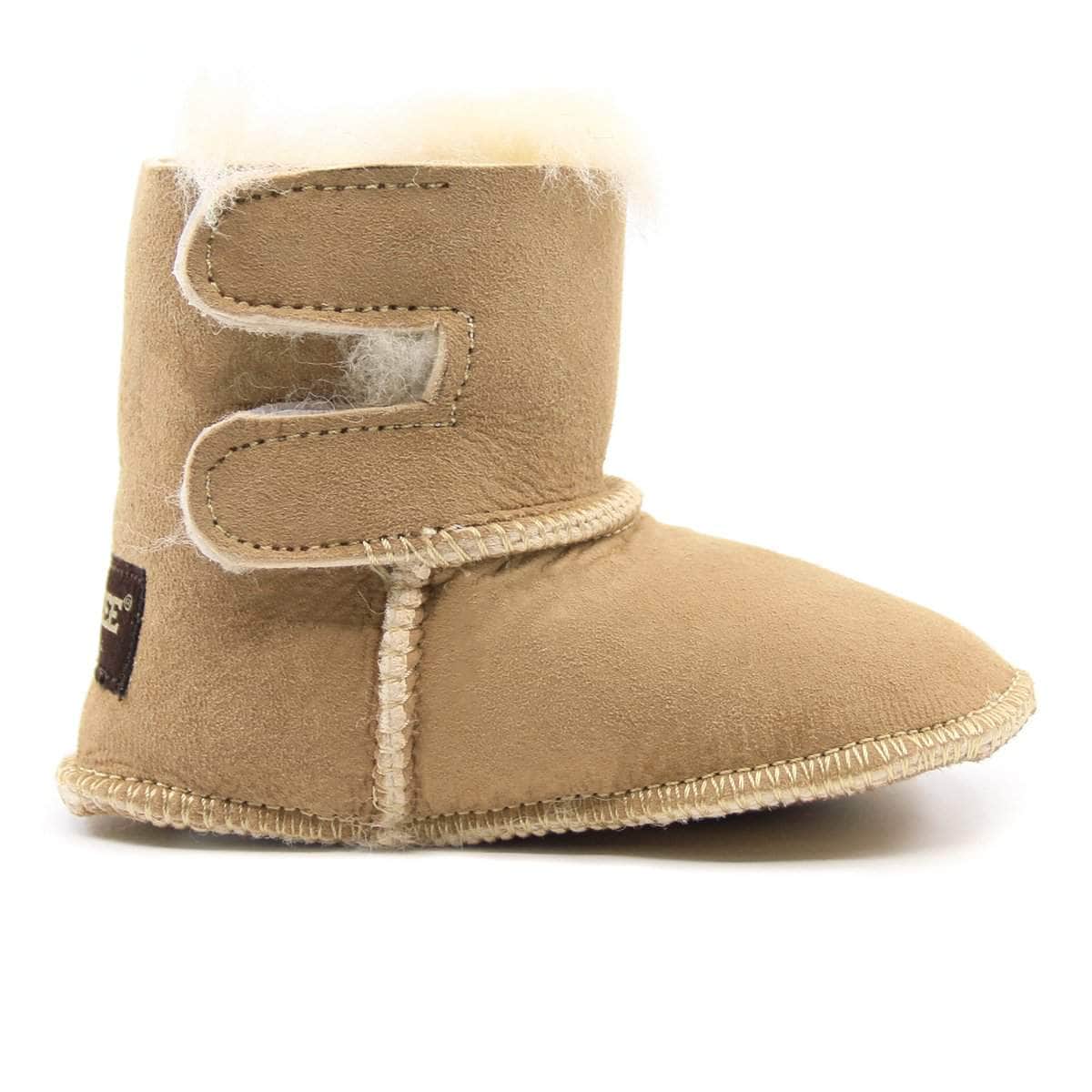 Small UGG baby boots in soft sand color, featuring plush lining and durable soles, designed for infants aged 0-3 months.
