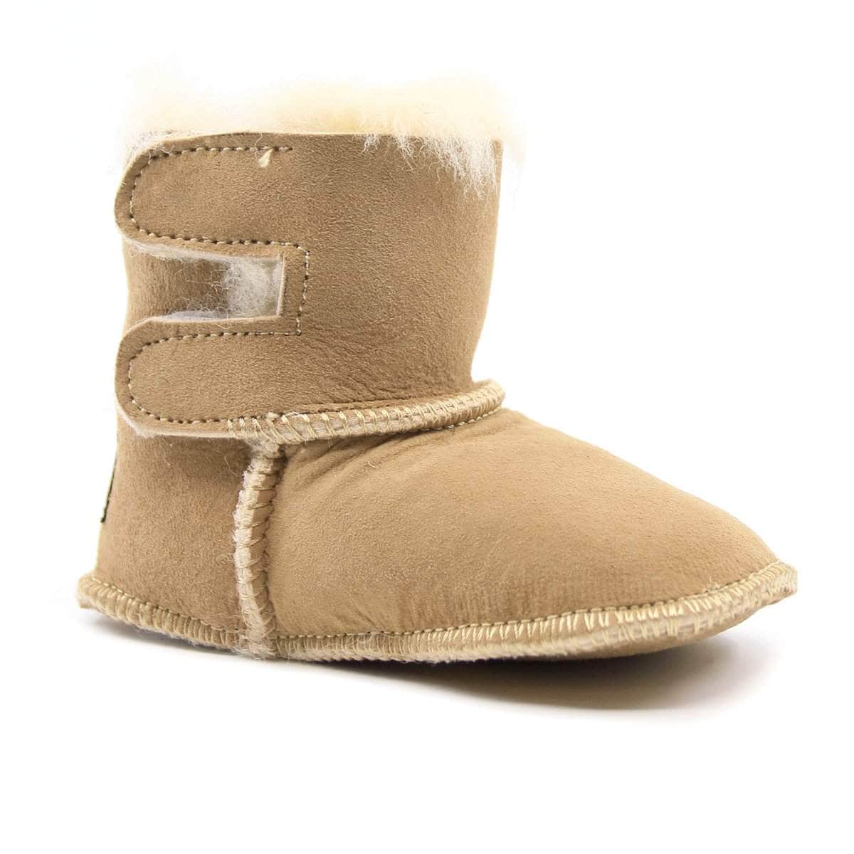 Pink UGG baby boots with soft shearling lining and slip-on design, perfect for little feet.